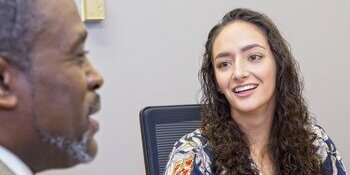 A female personnel services staff member smiling during a meeting.